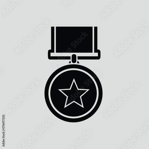 Black and white icon of a medal with a star in the center and a ribbon attached above on gray background