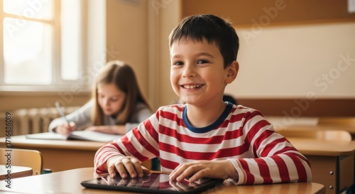 Young boy smiling in a classroom with a tablet