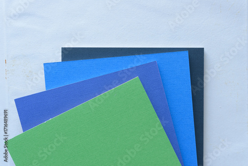 green, blue, and black crafting square pads on blank paper