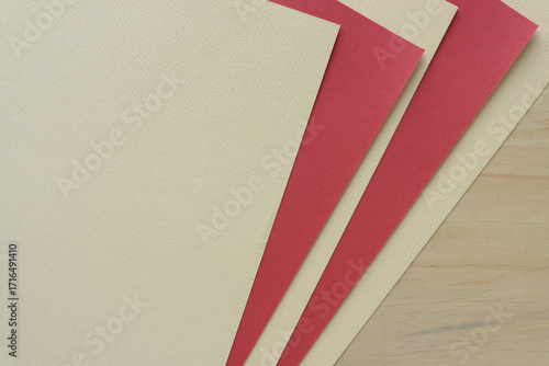 cream and red paper arranged staggered on wood