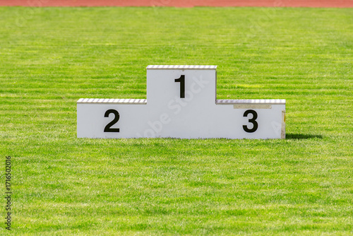 Vacant White Victory Podium With Numbers One Two And Three On A Lush Green Sports Field