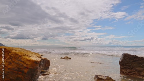 Rock fragments in the surf, waves crashing onto a rocky shore, a real-time video demonstrating the power of the elements, and rocks as a backdrop for advertising seafood