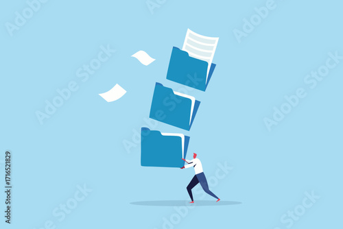 Man struggling to hold a tall stack of blue file folders with papers flying around