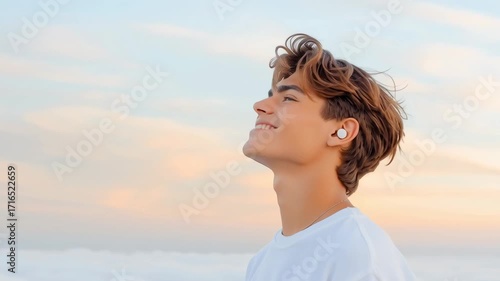Young man profile amid clouds — portrait against sea mist and cliffs; ideal for travel videos and inspirational reels.