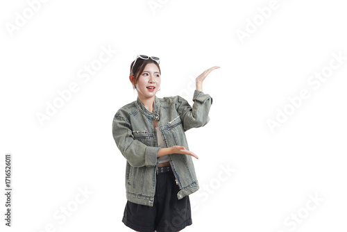 Fotografie Enthusiastic Gesture: A stylish individual stands poised against a minimalistic backdrop, presenting or indicating with open hands, embodying a sense of excitement, allure, and persuasive charm