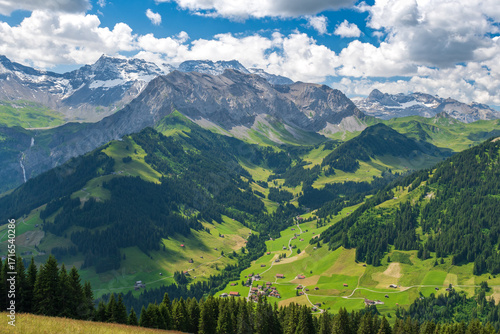 Scenic alpine landscape with green meadows, towering mountains, and clear blue summer skies in the heart of the Swiss Alps
