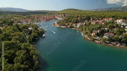 Drone footage of Vrboska harbor on Hvar, Croatia. Aerial view of yachts, marina and Mediterranean architecture with red rooftops.