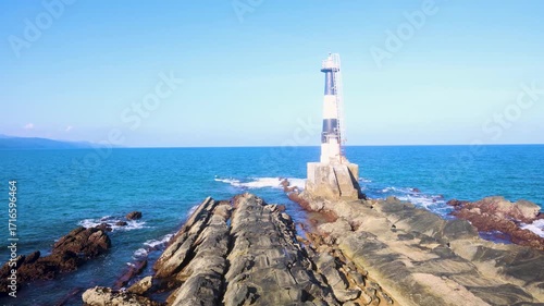 iconic light house of andaman ross island with blue sea water horizon and rocky shore at day