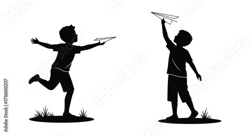 Two silhouetted boys joyfully launching paper airplanes in a grassy field