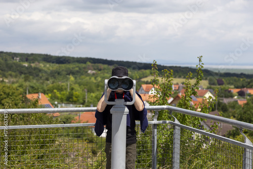Ein Junge beobachtet den See durch das Fernglas