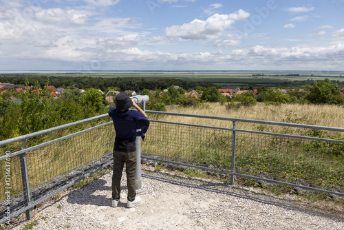 Ein Junge beobachtet den See durch das Fernglas