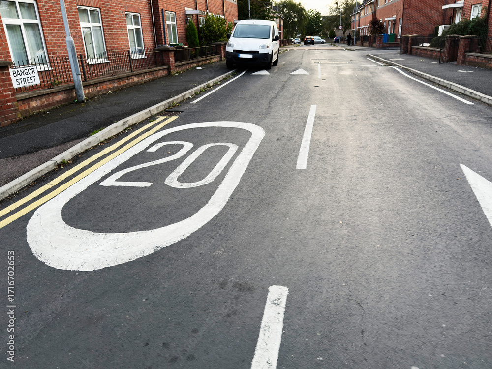 Obraz premium Quiet residential street in Manchester showing speed sign and parked vehicles