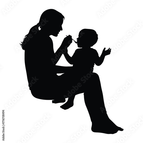 Mother feeding baby with spoon silhouette