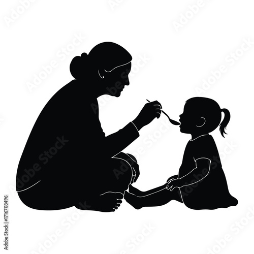 Mother feeding baby with spoon silhouette