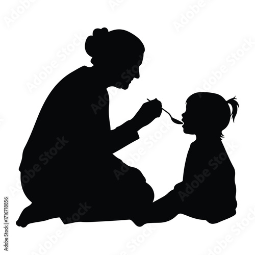 Woman feeding child with spoon silhouette