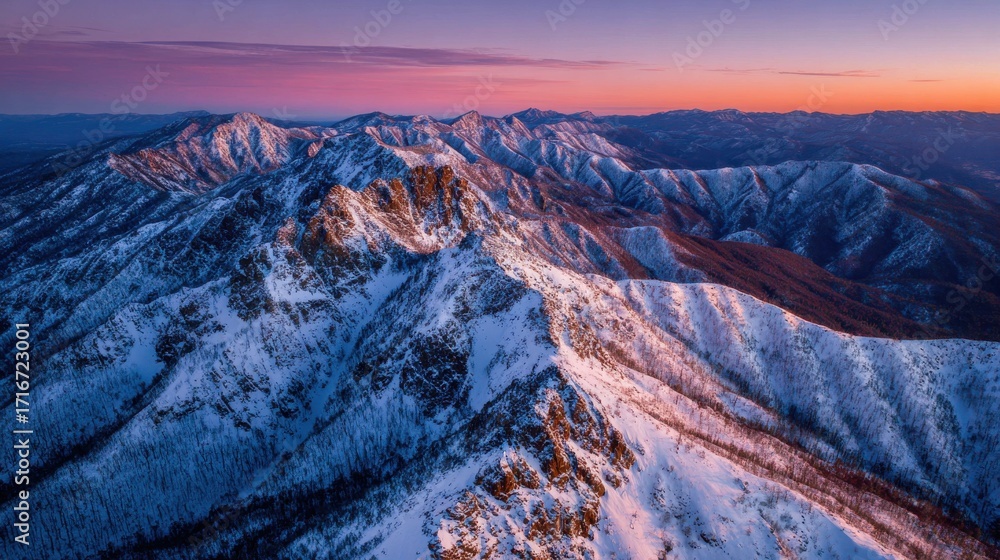 Obraz premium Snow covered mountain peaks at sunrise 