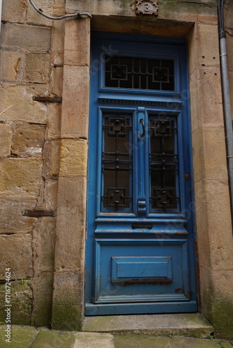 Porte ancienne bleue entourée de pierre