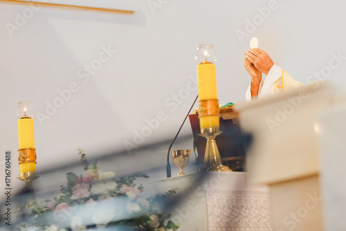 Catholic priest celebrating Holy Mass during liturgy with chalice, Bible, and liturgical vestments inside church, Eucharist and communion ceremony in Christian tradition