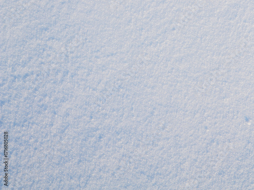Natural snow texture. The surface of clean fresh snow. Snowy ground. Winter background with snow patterns. Perfect for Christmas and New Year design. Closeup top view.