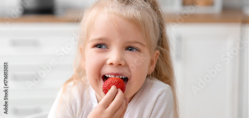 Smiling little girl eating ...