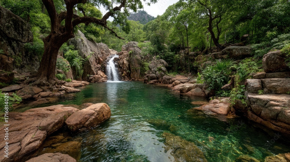 Naklejka premium and keyword list based on the imageWaterfall Cascading into Calm Emerald Pool Surrounded by Lush Trees in Nature.