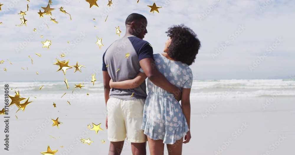 Fototapeta premium Standing adult couple holding waists at sandy beach shoreline, with decorative golden star shapes