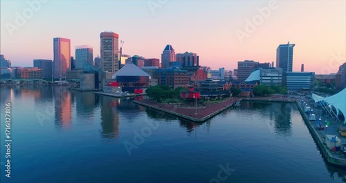 Aerial view of Baltimore's Inner Harbor at sunrise, Maryland, USA. The photo showcases the city's skyline, waterfront attractions, and urban landscape.