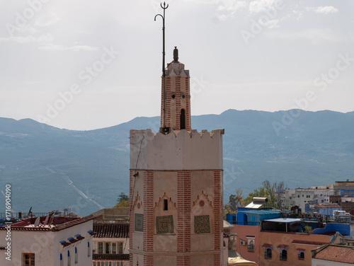 Close-up of mosque minaret with mountain backdrop in Chefchaouen, Morocco