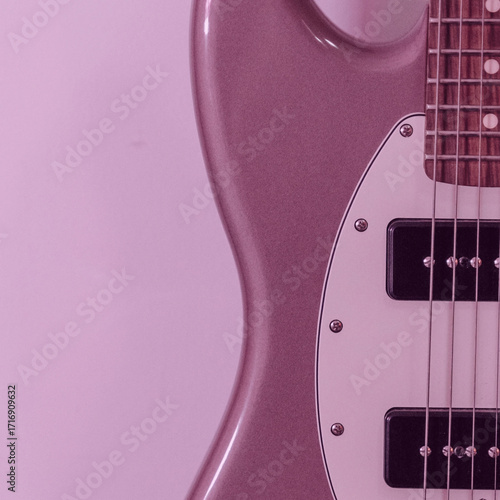 Close up of a mauve purple electric guitar body and strings.