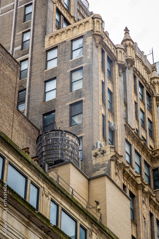Fototapeta premium Fifth Avenue in Manhattan with skyscrapers, trees, and yellow taxi