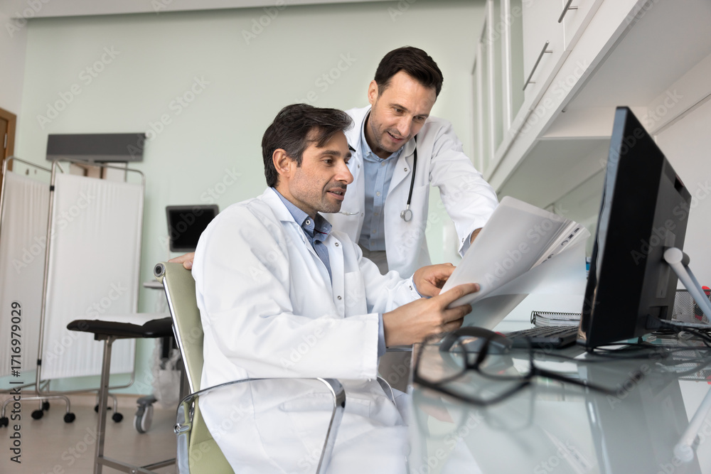 Obraz premium Interested male doctors examine unusual patient case interpret test results