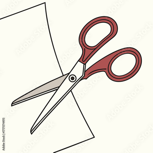 Red handled scissors cutting a piece of paper craft