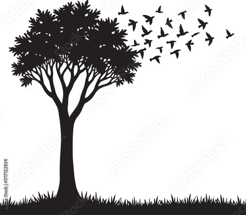 Black silhouette of a tree with birds flying away from branches
