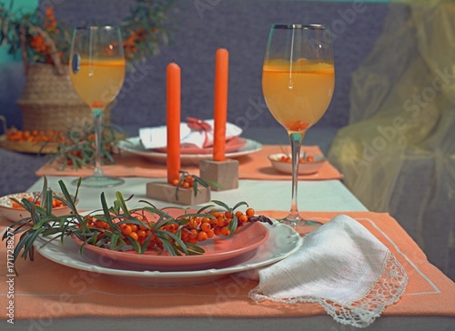 Sea buckthorn branches and sea buckthorn juice on the table