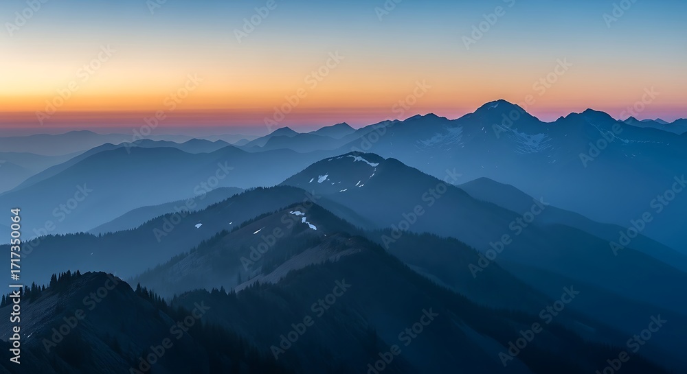 Fototapeta premium Layered mountain ranges at dusk with a gradient sky of orange and blue.