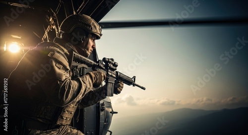 Soldier holding assault rifle while looking out of helicopter. Military special operations. Air mission for armed forces concept.