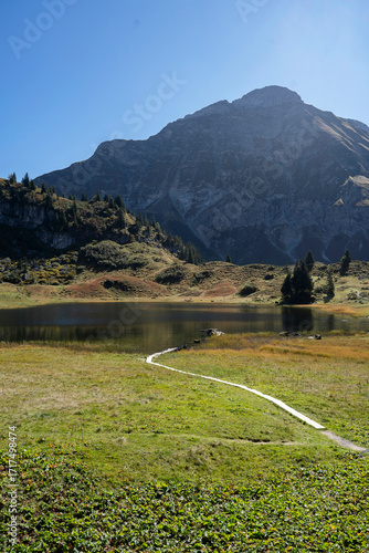 deep blue lake Körbersee in the mountains of Vorarlberg in Warth Schröcken with reflection of the alpine landscape 