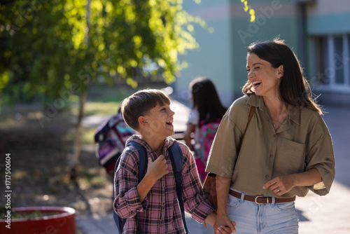 Woman picking up son from school and holding hands