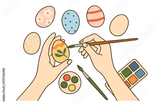 Easter preparation concept top view. Hands painting traditional decorated eggs with a brush and watercolor paints. Spring holiday DIY craft hobby for a greeting card or banner.