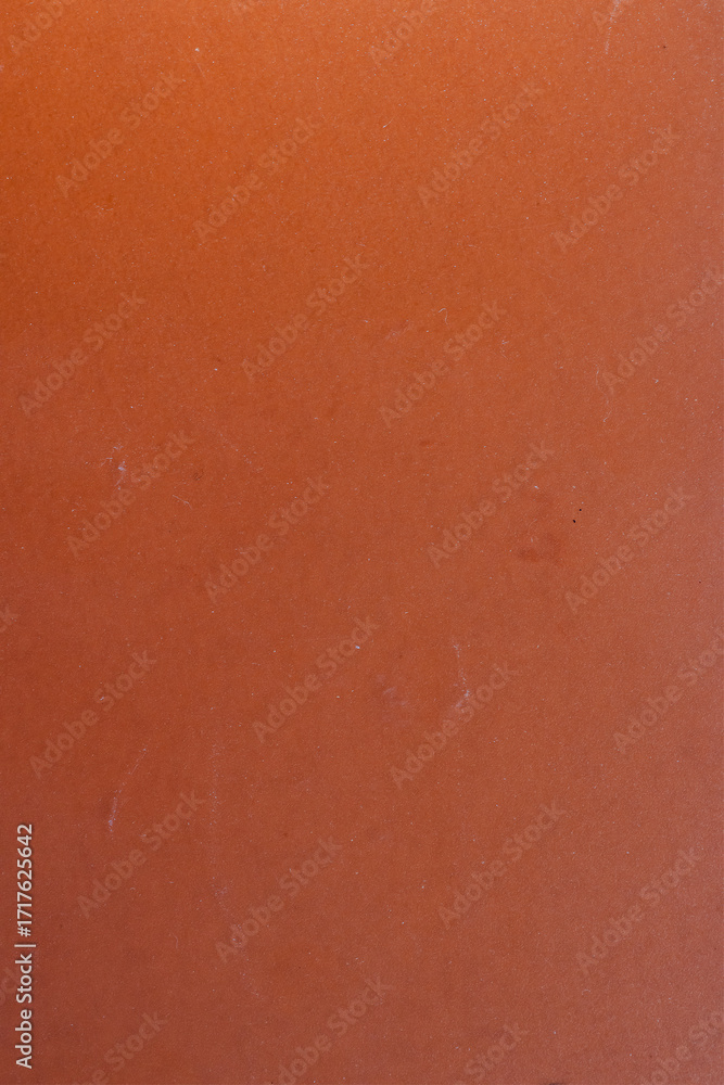 Fototapeta premium orange plastic surface with visible dust and small scratches. Minimalistic textured background with imperfections, suitable for abstract design, grunge style, or industrial themes.