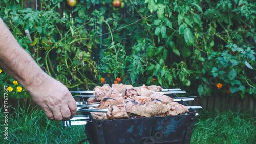 Shashlik on skewers is being cooked on charcoal in a barbecue close-up.