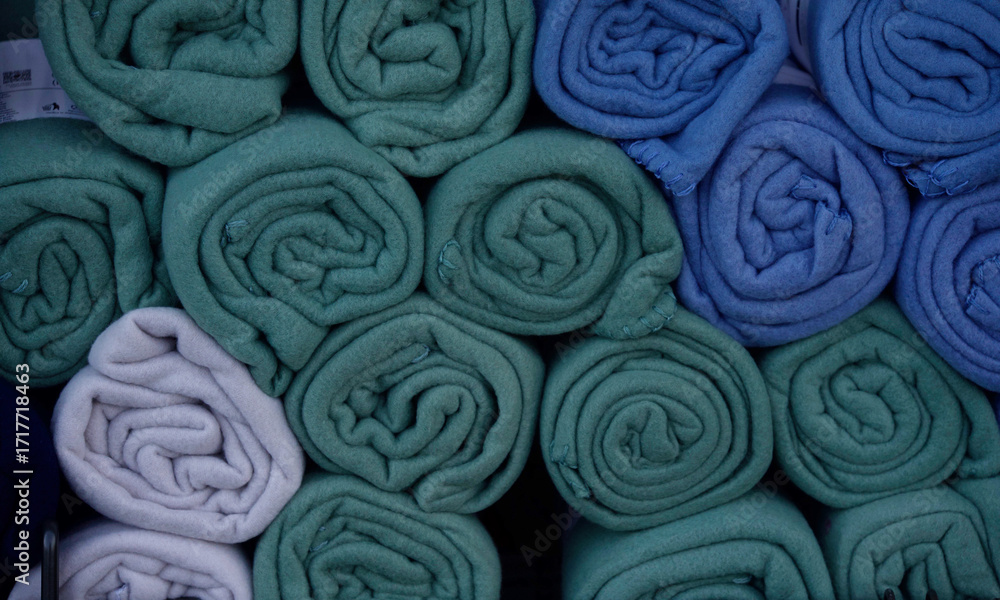 Fototapeta premium Rolled fleece plaids in various shades of blue and green