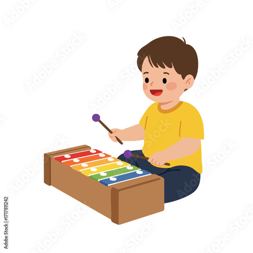 a toddler sitting on the floor, wearing a bright yellow t-shirt, happily striking the colorful keys of a xylophone with two small mallets