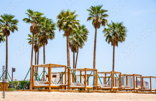 Fototapeta Naklejka Na Ścianę i Meble -  White sand beach with palms and cabanas. Doha, Qatar