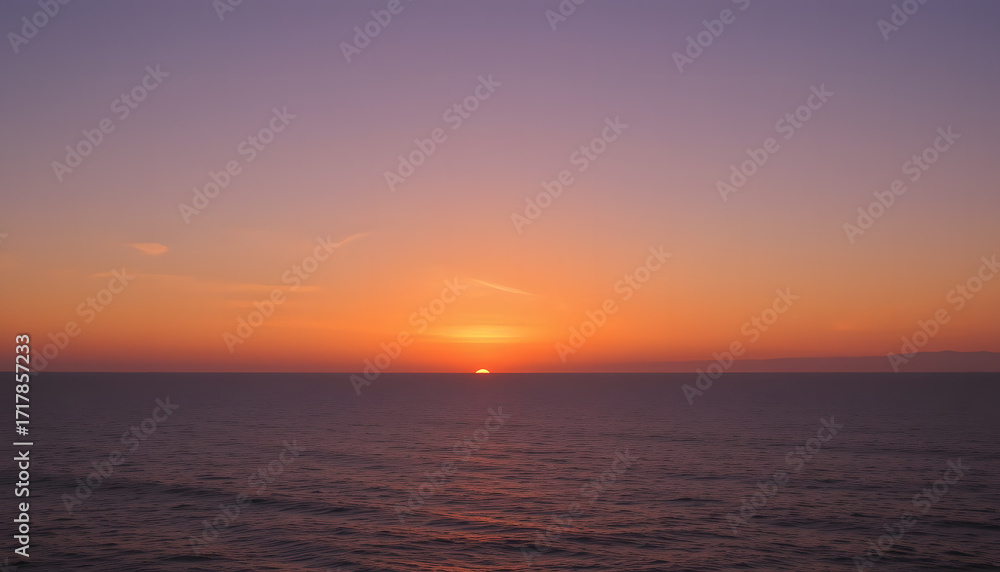 Obraz premium Serene Seascape at Sunset: The sun dips below the horizon, painting the sky with vibrant hues of orange, pink, and purple as it casts a golden glow upon the calm ocean.