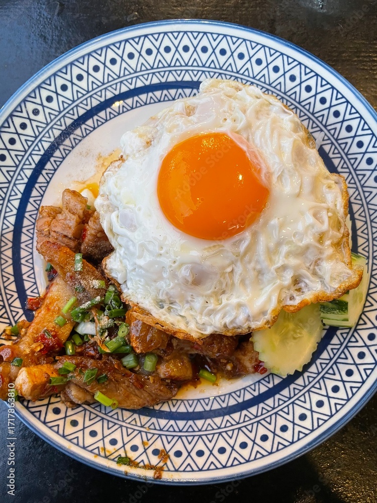 Φωτογραφία Egg and Rice Delight: A vibrant capture of a delectable dish featuring a perfectly cooked egg with a golden yolk atop a bed of rice and grilled meat