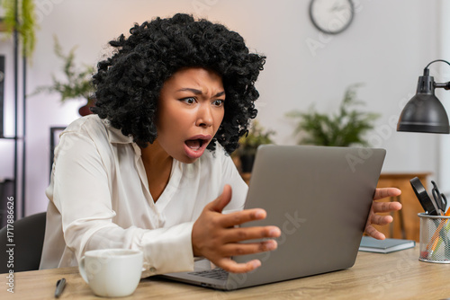 Fotografía African American businesswoman at home office frowns at laptop upset by game defeat fail, rejection email