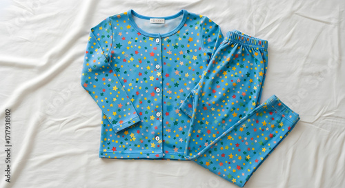 A pair of blue children's pajamas with a colorful star pattern, laid out flat on a white surface.