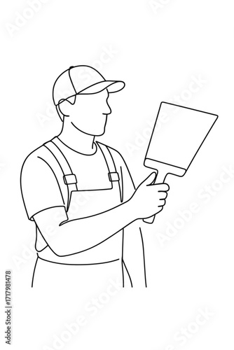 Plasterer holding large trowel while wearing cap and overalls  