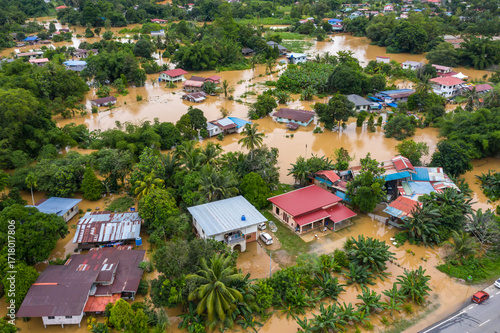 Aerial view of a flood in Penampang, Sabah, Malaysia. Overflowing river causes severe flooding, affecting houses and roads. Natural disaster and climate change impact in Southeast Asia.